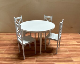 May include: A white round table with four white chairs. The table and chairs are made of wood and have a simple design.