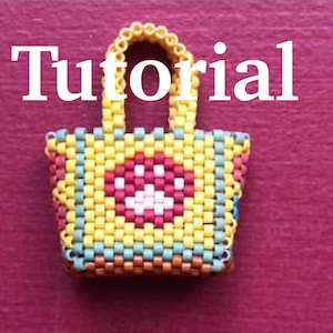 May include: A small, colorful beaded tote bag with a heart design. The bag is made of yellow, red, orange, blue, and green beads. The heart is white with a red outline. The bag has a beaded handle.