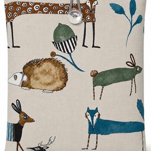May include: A rectangular beige fabric pouch featuring a repeating illustration of various animals including a brown patterned fox, a green rabbit, a blue fox, a hedgehog, and a deer, secured at the top with a grey cord and a clear plastic button.