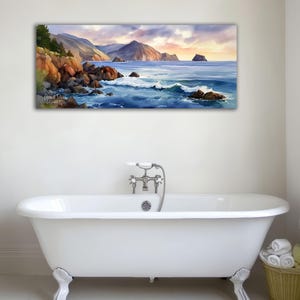 K&ouml;nnte beinhalten: Ein rechteckiges Landschaftsgem&auml;lde zeigt eine K&uuml;stenlandschaft mit Felsen, Meereswellen und einem Sonnenuntergang. Das Kunstwerk wird &uuml;ber einer wei&szlig;en Badewanne mit L&ouml;wenf&uuml;&szlig;en pr&auml;sentiert.