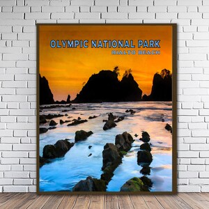 May include: A framed print depicting Olympic National Park, Rialto Beach. The artwork shows a sunset over the sea, with dark rock formations and a rocky beach. The text "Olympic National Park Rialto Beach" is displayed at the top of the image.