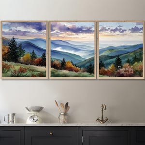 Puede incluir: Un tríptico de pinturas de paisajes en acuarela enmarcadas. La obra representa una cordillera con tonos azules y verdes, con árboles y follaje en tonos naranja, amarillo y verde. El cielo presenta tonos morados, azules y naranjas. El texto "Shenandoah National Park" es visible.