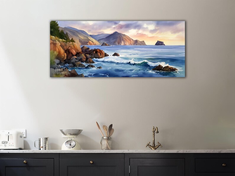 K&ouml;nnte beinhalten: Ein Panorama-Aquarellgem&auml;lde einer K&uuml;stenlandschaft. Das Kunstwerk zeigt eine felsige K&uuml;stenlinie mit tosenden Wellen, Bergen und einem Sonnenuntergangshimmel. Das Gem&auml;lde hat eine beruhigende und heitere Atmosph&auml;re, mit der Signatur des K&uuml;nstlers.