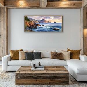 K&ouml;nnte beinhalten: Ein gerahmtes Landschaftsgem&auml;lde zeigt eine K&uuml;stenlandschaft mit felsigen Klippen, tosenden Wellen und einem ruhigen Ozean unter einem Sonnenuntergangshimmel. Das Kunstwerk weist warme T&ouml;ne von Orange, Blau und Gold auf.