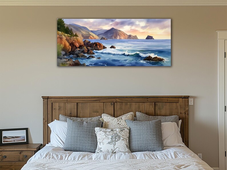 K&ouml;nnte beinhalten: Ein Landschaftsgem&auml;lde einer K&uuml;stenlandschaft. Das Kunstwerk zeigt eine felsige K&uuml;stenlinie mit Wellen, die gegen die Felsen schlagen. Berge sind im Hintergrund unter einem Sonnenuntergangshimmel. Das Gem&auml;lde h&auml;ngt &uuml;ber einem h&ouml;lzernen Bettrahmen.