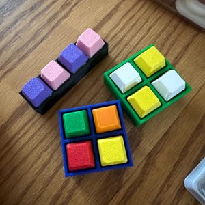 Puede incluir: Un juego de tres tazas de cerámica con un acabado moteado y mate. Las tazas son de color crema, gris claro y gris oscuro. Cada taza tiene un diseño simple y minimalista.