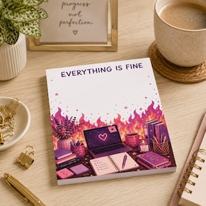 May include: A rectangular notepad with the text EVERYTHING IS FINE printed at the top. The design features a vibrant illustration of a desk with a laptop, books, a mug, and a vase of lavender, all set against a background of pink and purple flames.