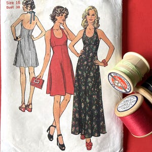 May include: Vintage Simplicity sewing pattern, number 6916, featuring illustrations of three halter dresses. The pattern is for Misses size 16, with a bust size of 38 inches. Spools of thread in red, green, and black are visible.