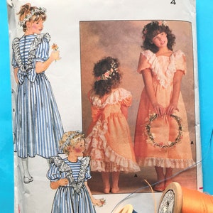 May include: A vintage sewing pattern for a girls' dress. The pattern is for a dress with a ruffled neckline and a bow at the back. The pattern is for size 4. The pattern is from Butterick and the pattern number is 4768.