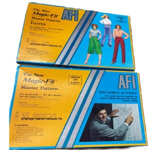 May include: Two rectangular boxes for The New Magic-Fit Master Pattern by AFI. The yellow and blue packaging features illustrations of pants, text detailing contents, and a photograph of a person working with a sewing pattern on a drafting table.