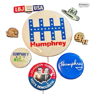May include: A collection of vintage political campaign buttons and pins. The buttons feature the names "Humphrey" and "Johnson Humphrey", with patriotic red, white, and blue color schemes. Some pins have the initials "LBJ".