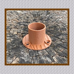 May include: A brown, cylindrical object with a textured surface and a circular base. The base has two small holes. The object is made of a reddish-brown material and sits on a weathered wooden surface.