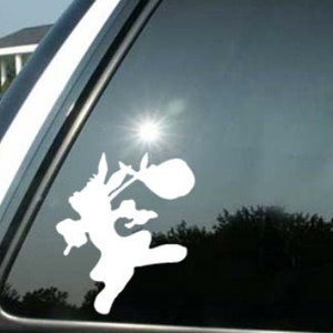 May include: White vinyl car decal of a cartoon stork carrying a bundle. The decal is applied to a car window, with the sun reflecting off the glass. The image is a silhouette of the stork.