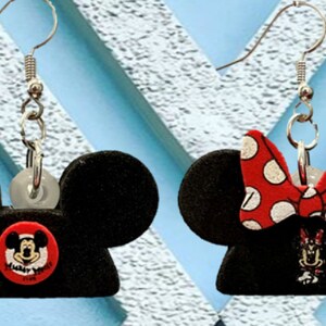 May include: Black Mickey Mouse and Minnie Mouse earrings. The Mickey Mouse earring has a red button with Mickey's face and the words "Always Smile". The Minnie Mouse earring has a red bow with white polka dots.