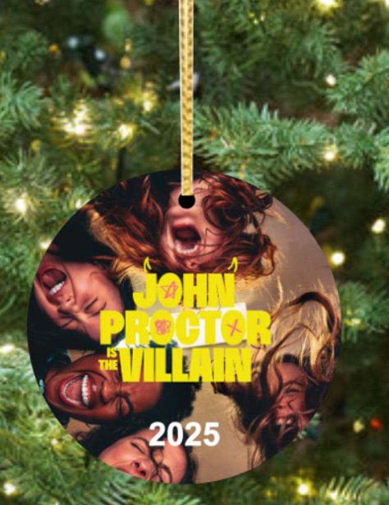 Puede incluir: Adorno navide&ntilde;o redondo con una cuerda dorada. Presenta un collage de caras con la boca abierta y el texto "JOHN PROCTOR IS THE VILLAIN 2025" en amarillo.