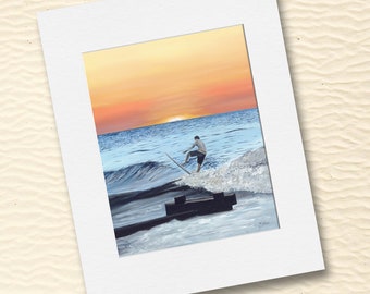 May include: A painting of a person surfing on a wave at sunset. The sky is a vibrant orange and yellow, and the water is a deep blue. The person is wearing a blue shirt and shorts, and the surfboard is white.