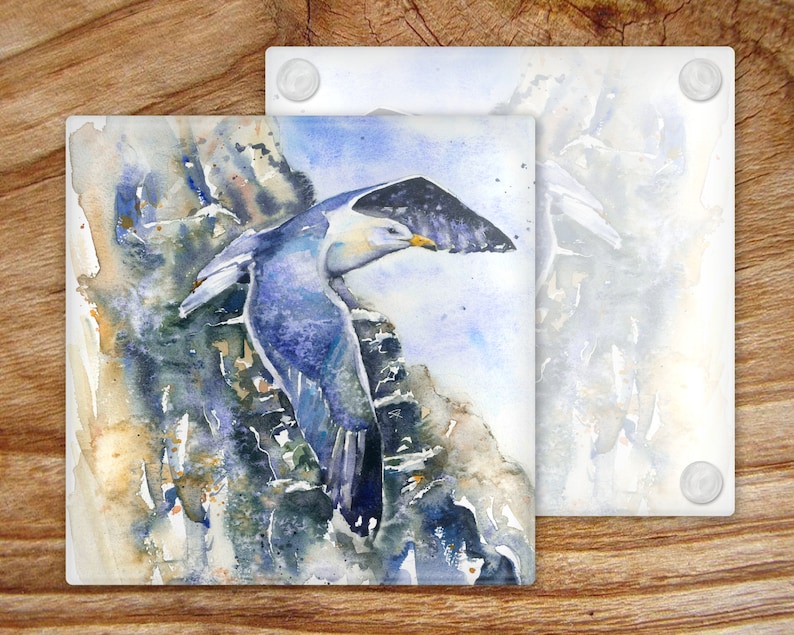May include: A watercolor painting of a blue and white seagull perched on a rocky cliff. The seagull is in flight, with its wings spread wide. The background is a soft blue and white, with hints of yellow and green.