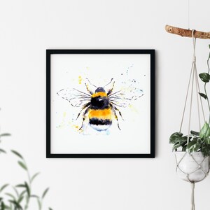 Puede incluir: Una pintura de acuarela de un abejorro con rayas amarillas y negras, rodeado de un fondo de acuarela azul claro y amarillo.