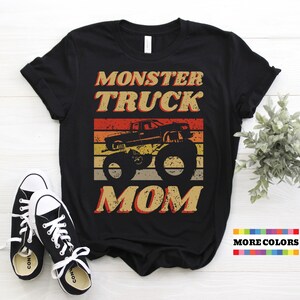 Op de afbeelding: Zwart T-shirt met een vintage-stijl grafische afbeelding van een monstertruck en de tekst "Monster Truck Mom".