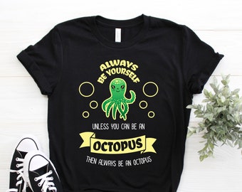 May include: Black t-shirt featuring a green octopus graphic and the text "Always be yourself unless you can be an octopus then always be an octopus".