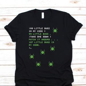 Pode incluir: Camiseta preta com aranhas pixeladas verdes e texto que diz: '>99 LITTLE BUGS IN MY CODE; 99 LITTLE BUGS >TAKE ONE DOWN; PATCH IT AROUND 127 LITTLE BUGS IN MY CODE. >_'