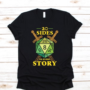May include: Black t-shirt with a green and yellow 20-sided die graphic. The die is surrounded by two crossed swords. The text "20 SIDES TO EVERY STORY" is printed below the die.