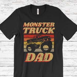Puede incluir: Camiseta negra con un gr&aacute;fico de estilo vintage de un cami&oacute;n monstruo con el texto "Monster Truck Dad" en una fuente desgastada.