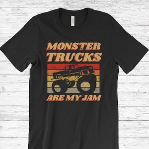 May include: Black t-shirt with a vintage-style graphic of a monster truck. The graphic features a red monster truck with large tires and the text "Monster Trucks Are My Jam".