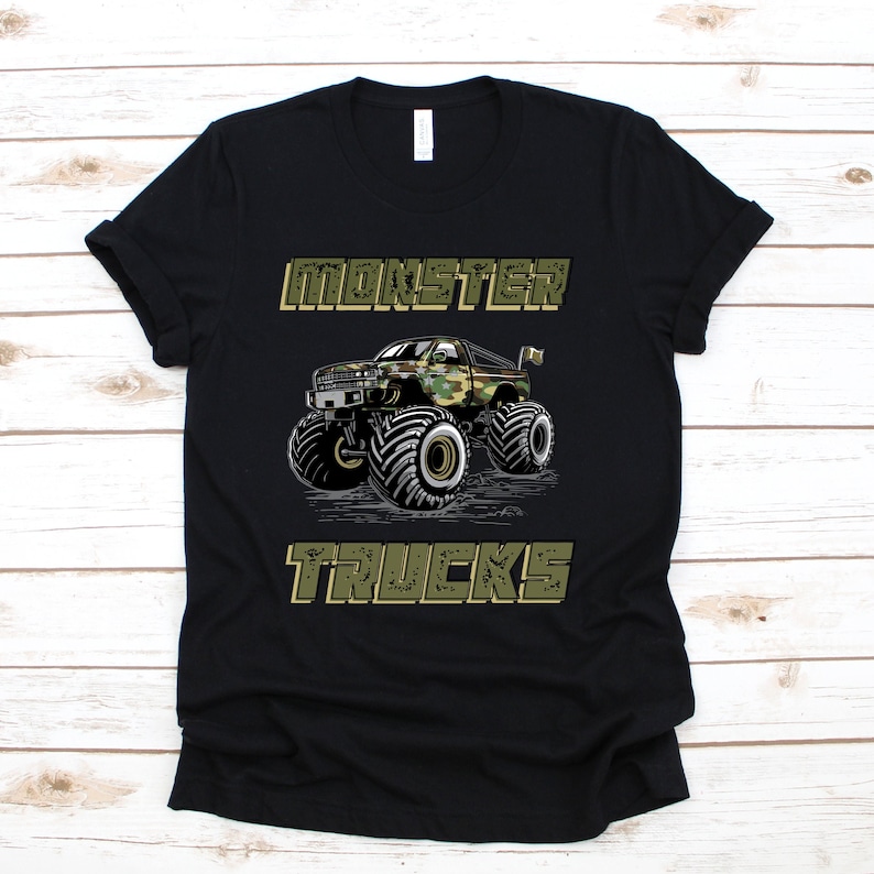 May include: Black t-shirt with a green camouflage monster truck graphic and the text "MONSTER TRUCKS".