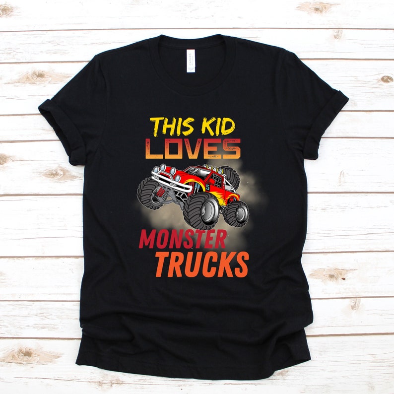 May include: Black t-shirt with a graphic of a monster truck and the text "This Kid Loves Monster Trucks".