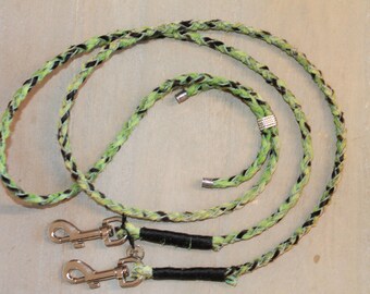 May include: A braided dog leash with black and green accents. The leash has two silver clips and a silver bead.