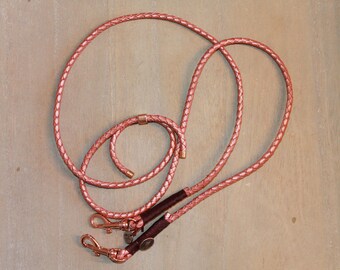 May include: A rose gold leather dog leash with two clips and a braided design.