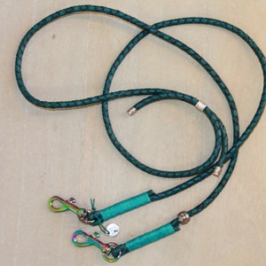 May include: A teal braided leather dog leash with two silver clasps and silver accents.