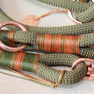 May include: A green and orange rope dog leash with rose gold hardware, including a ring and a clip.