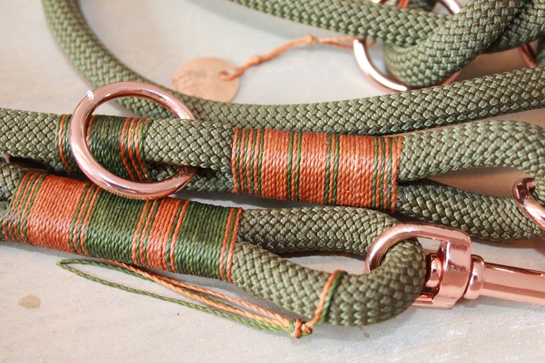 May include: A green and orange rope dog leash with rose gold hardware, including a ring and a clip.