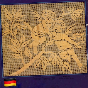 Può includere: Un motivo all'uncinetto dettagliato e a trama aperta in una tonalità giallo dorato, con un design floreale e di foglie. Il motivo è ambientato su uno sfondo scuro. Il testo "Modell 14" e "Größe: ca. 88 x 78 cm" sono visibili. L'immagine è incorniciata da un bordo blu.