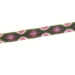 Op de afbeelding: Een groene, witte en roze vriendschapsband met een ruitpatroon.