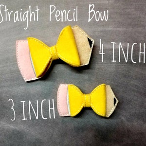 May include: Two felt pencil bows, one 4 inches and one 3 inches long, with yellow, pink, and tan colors. The bows have a pencil design with a black tip and are stitched with white thread. The text "Straight Pencil Bow" is above.