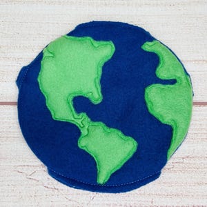 May include: A blue felt globe with green felt continents. The globe is a simple, handmade craft.