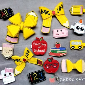 May include: A collection of school-themed hair clips and accessories. Includes yellow pencil-shaped bows, apple-shaped badges with text, a school bus clip, and a notepad clip. The accessories are in various colors, including yellow, red, and black.