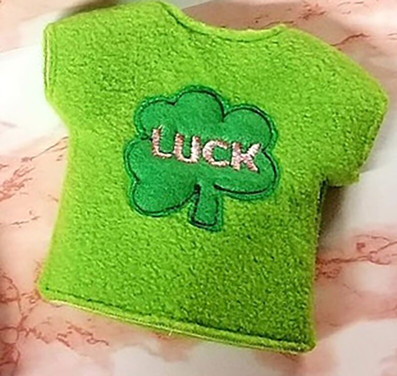 May include: Green felt t-shirt with a green shamrock and the word "LUCK" embroidered on it.