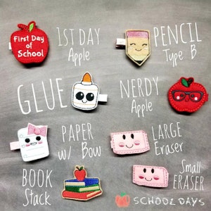 May include: A collection of school-themed hair clips, including an apple with "First Day of School" text, a pencil, a glue bottle, a stack of books, and erasers. The clips are in various colors and designs, perfect for back-to-school.