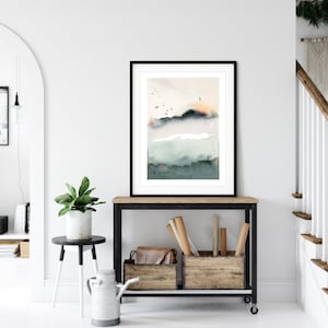 Può includere: Dipinto ad acquerello astratto incorniciato con una cornice nera, con sfumature di verde, nero e beige. L'opera d'arte è esposta su una consolle in legno con una cornice in metallo nero, accanto a casse di legno e una pianta in vaso.