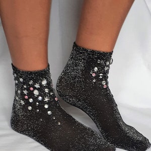 May include: A pair of black sparkly socks with silver glitter and pink and silver rhinestones.