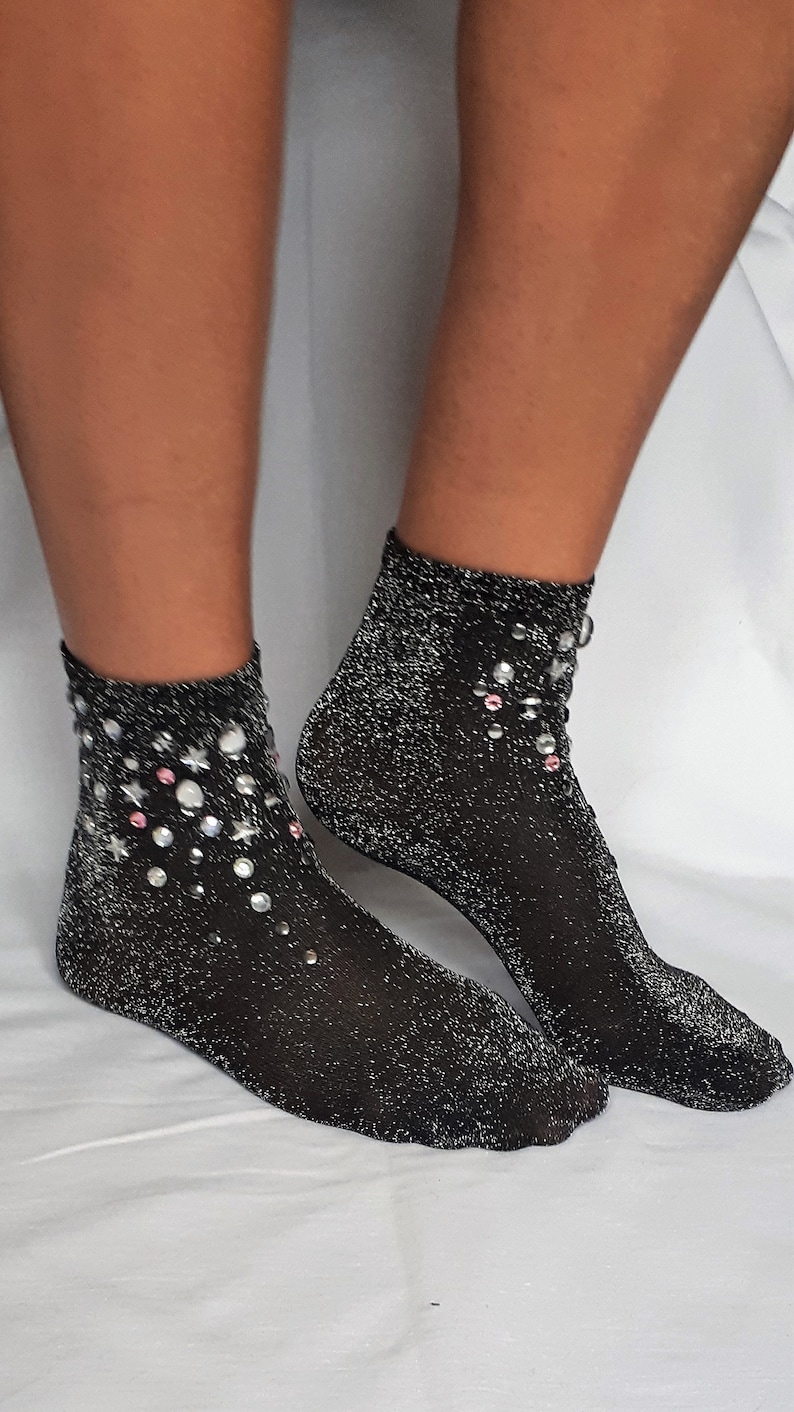 May include: A pair of black sparkly socks with silver glitter and pink and silver rhinestones.