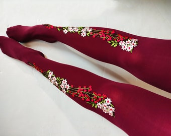 May include: Burgundy tights with embroidered floral designs in white, pink, and green.