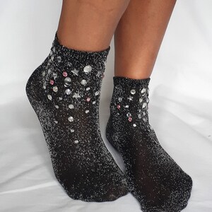 May include: A pair of black sparkly ankle socks with silver glitter and rhinestones.