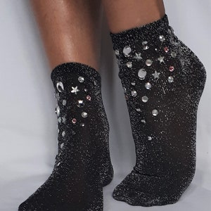 May include: A pair of black sparkly ankle socks with silver and pink rhinestones in a star and circle design.