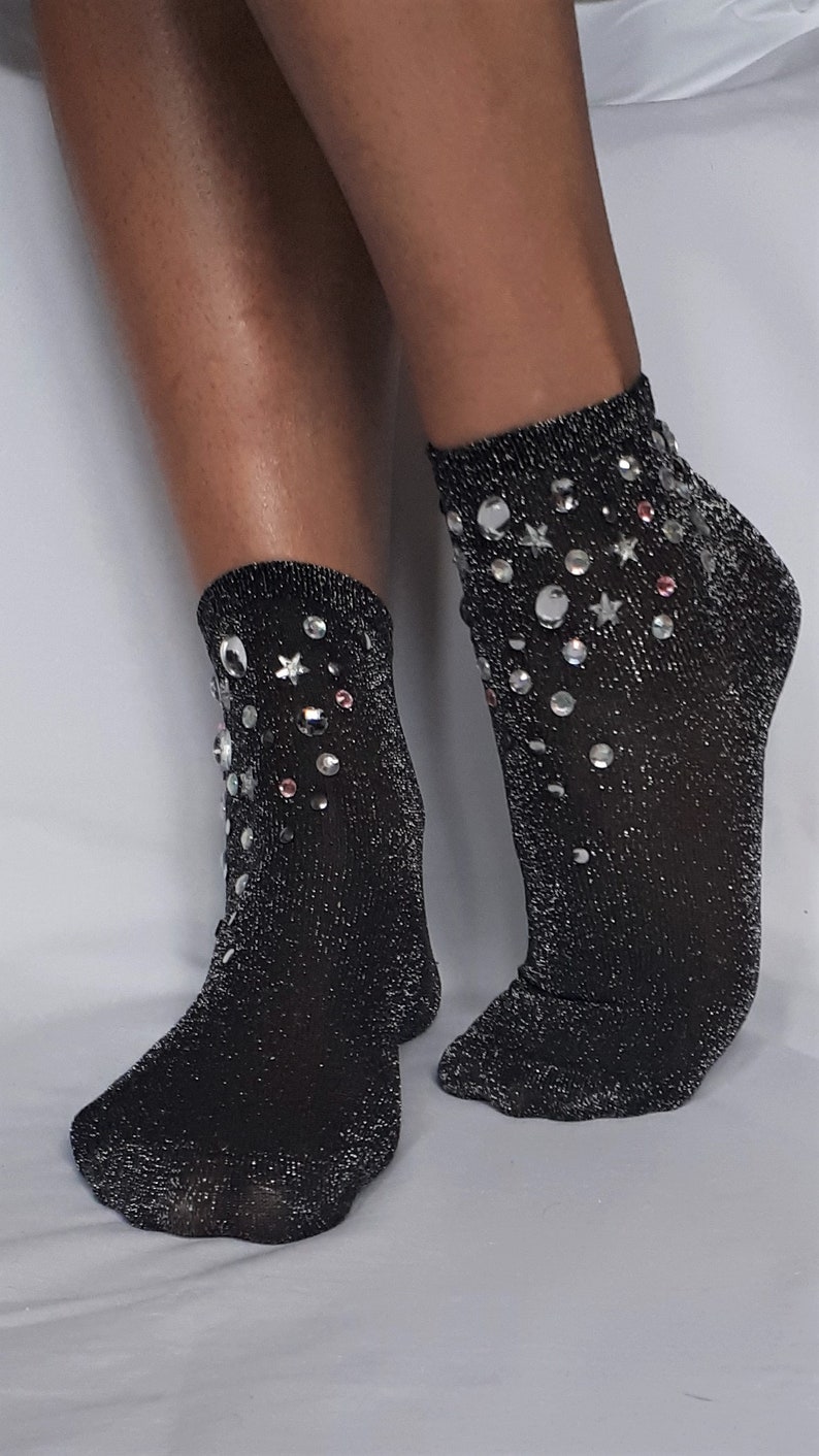 May include: A pair of black sparkly ankle socks with silver and pink rhinestones in a star and circle design.