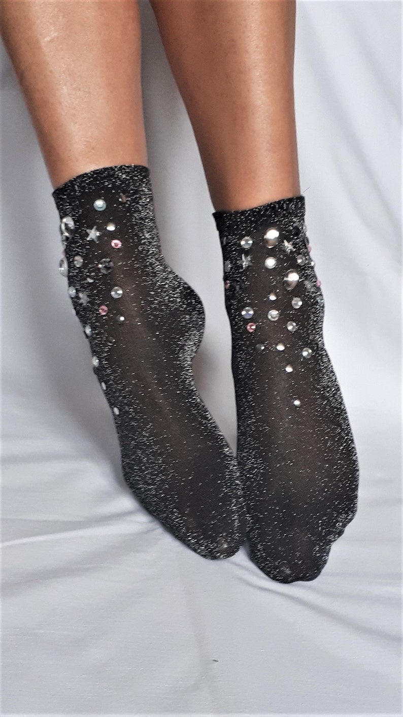 May include: A pair of black sparkly socks with silver and pink rhinestones in a star and circle design.